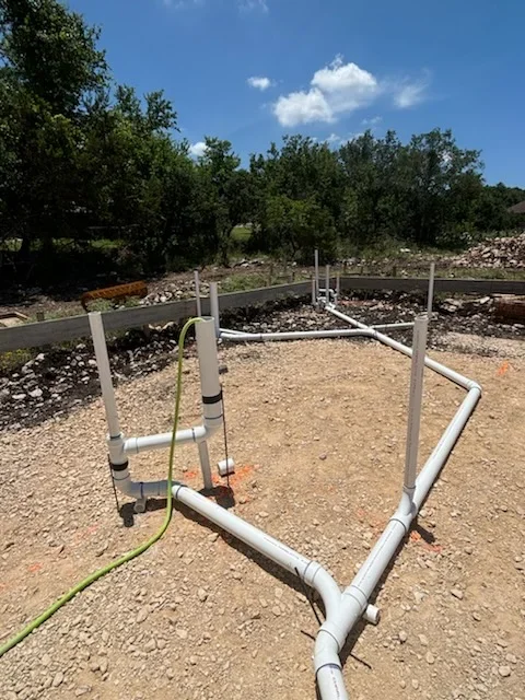PVC septic system piping with concrete posts installed in gravel drain field